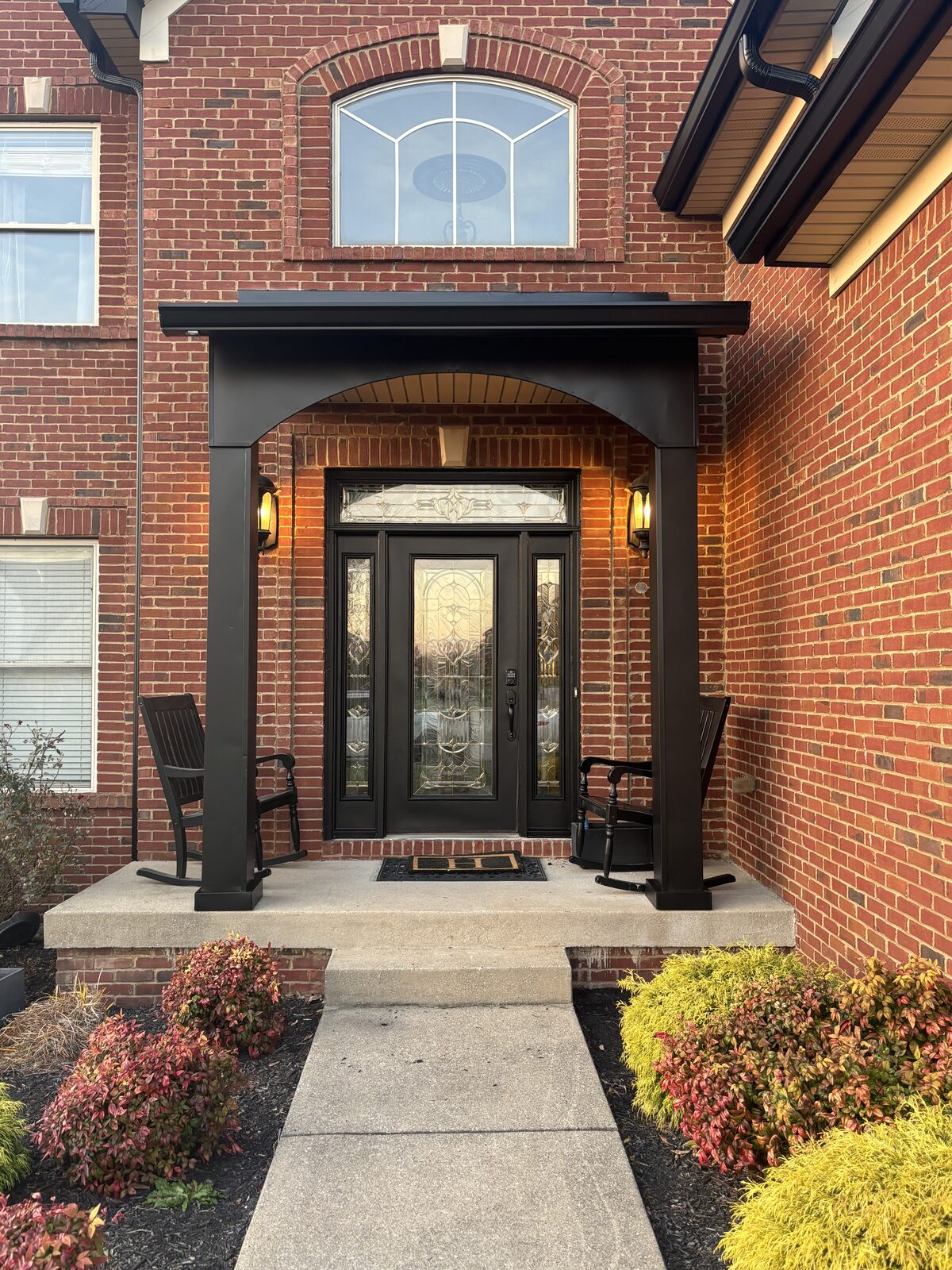 Front entry with black-painted trim, columns, and door after exterior painting in Heritage Place, Charlestown IN