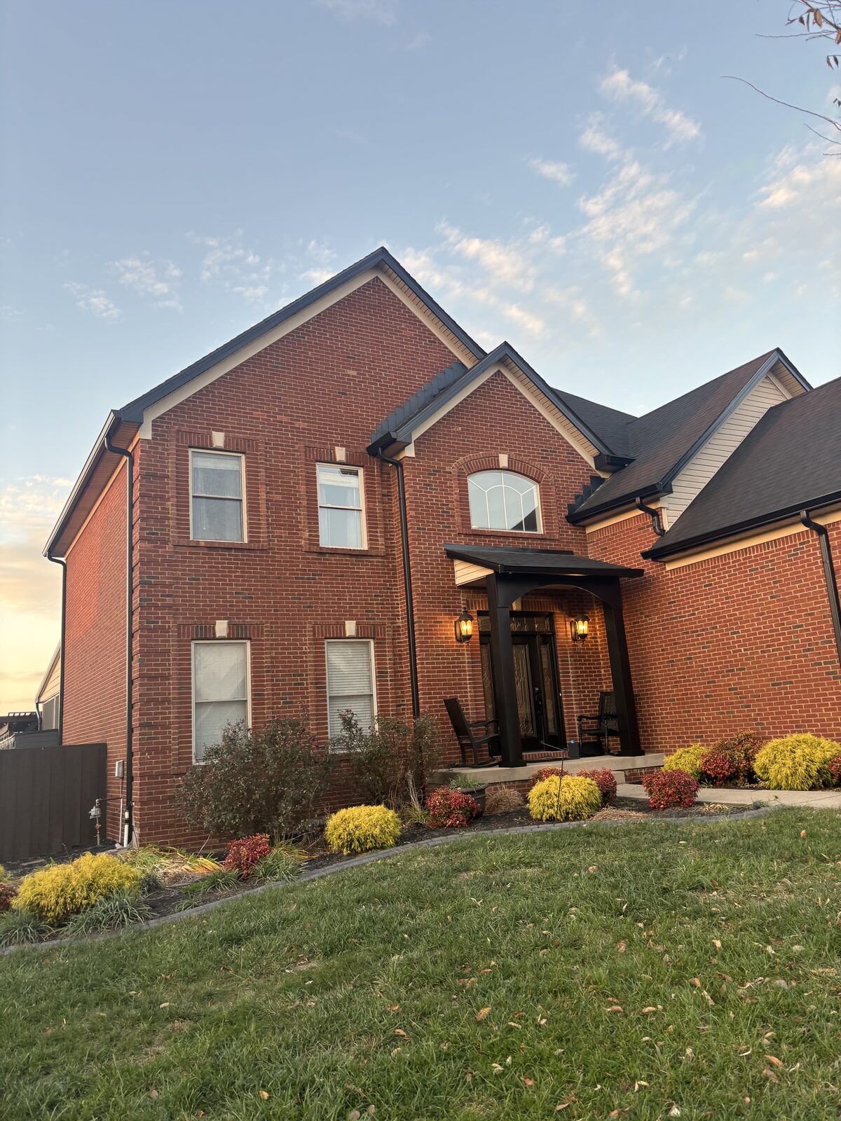 Full exterior view of a brick home with black-painted trim and entryway in Heritage Place, Charlestown IN