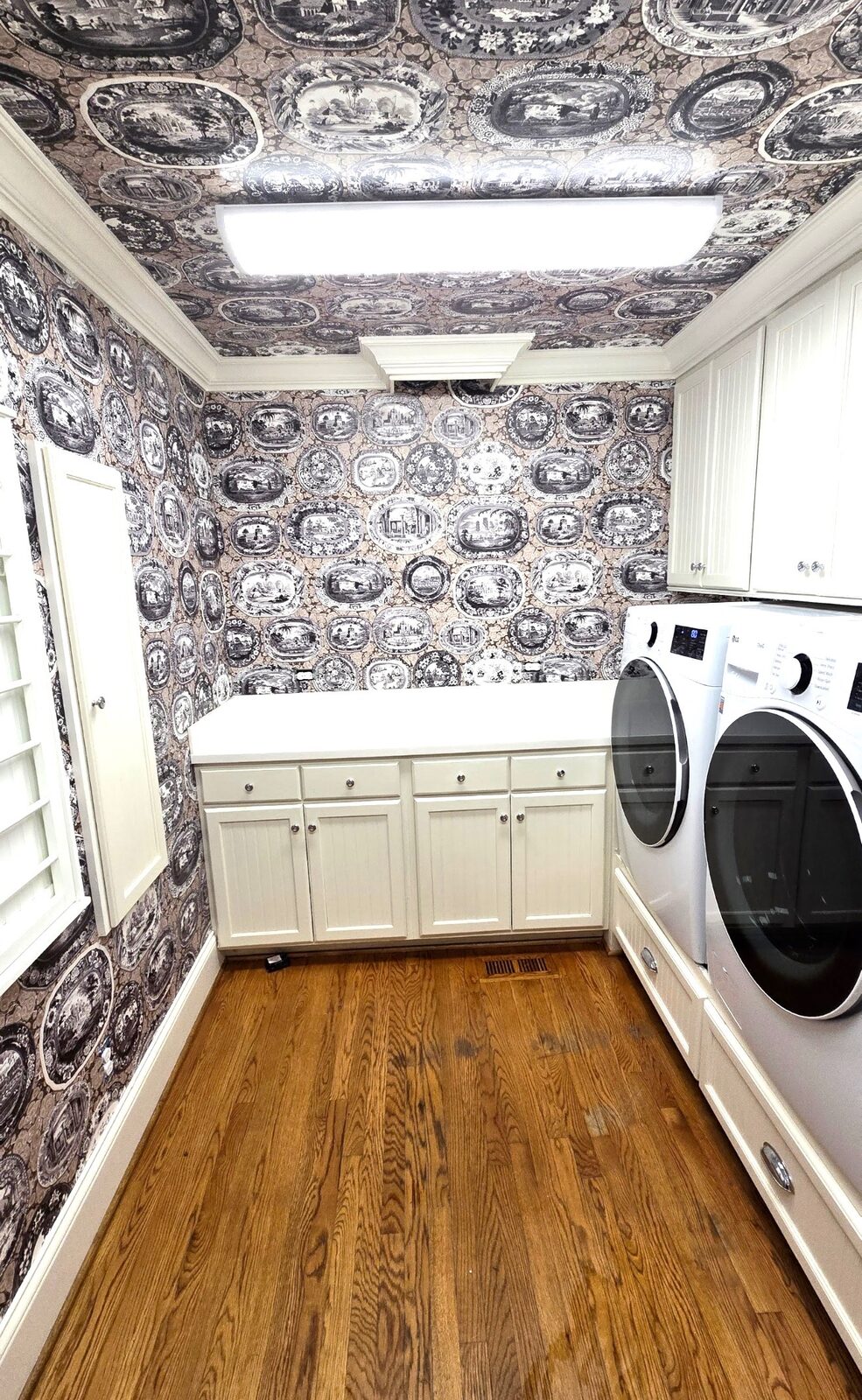 Laundry room with decorative plate print wallpaper on walls and ceiling in Louisville, KY