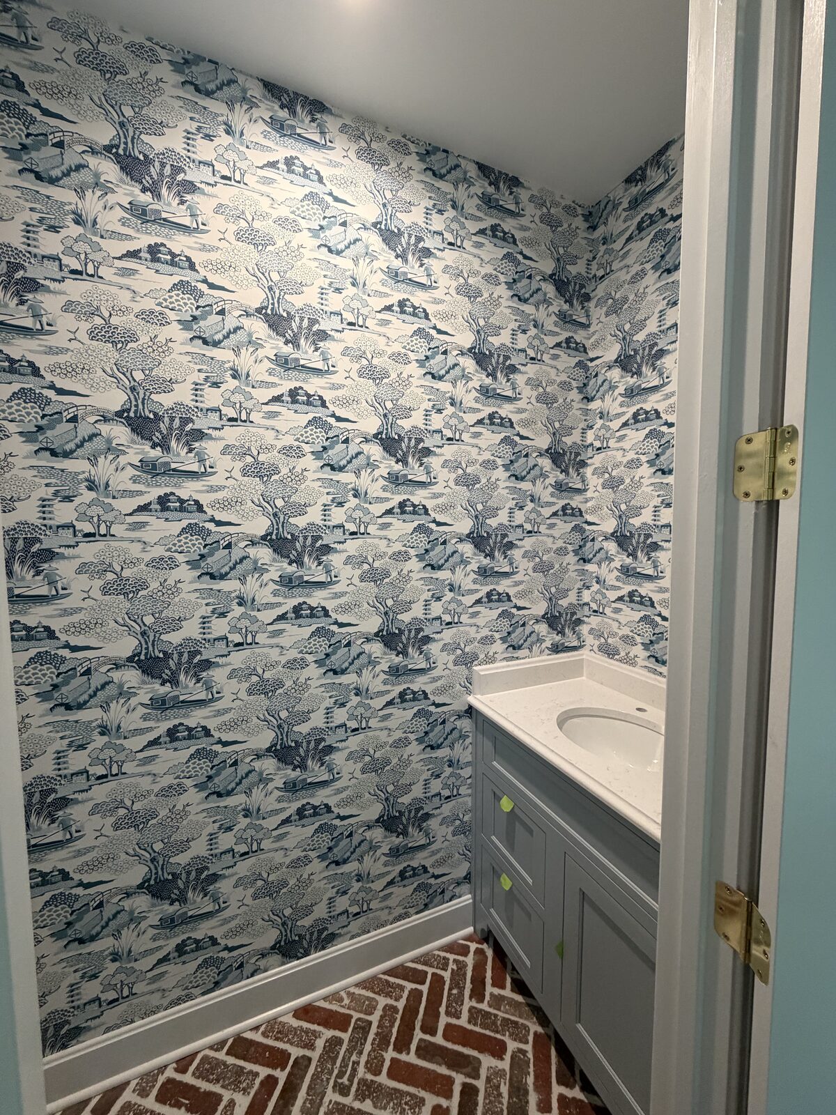 Powder room with blue and white chinoiserie toile wallpaper installed in Louisville, KY